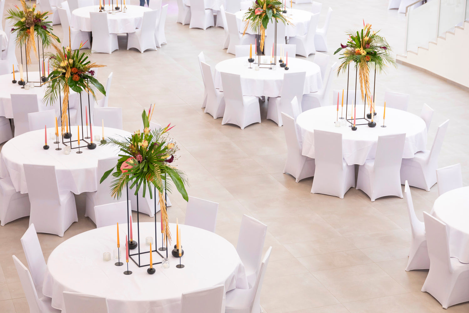 Blumendekoration auf weißen Tischen